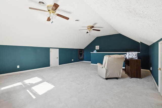 interior space featuring carpet floors, lofted ceiling, visible vents, a textured ceiling, and baseboards