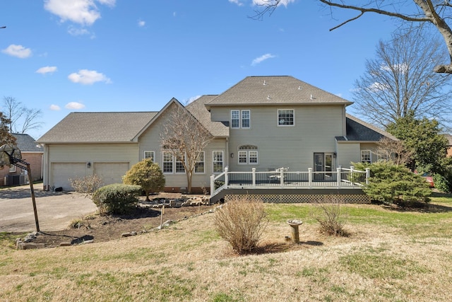 back of property with central air condition unit, a lawn, a garage, driveway, and a wooden deck