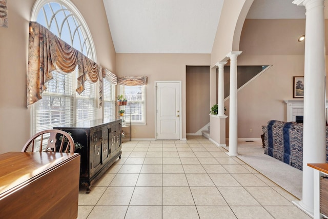 entrance foyer featuring light tile patterned floors, stairs, decorative columns, and baseboards