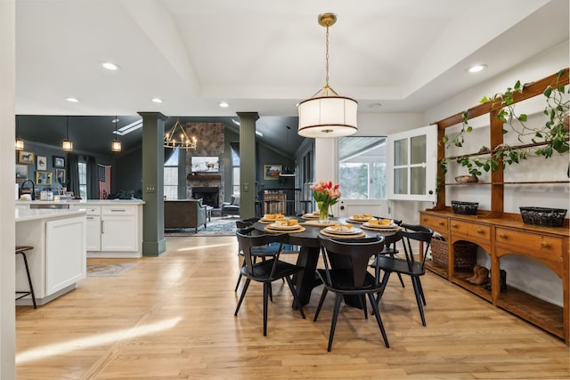 dining area with recessed lighting, a fireplace, a raised ceiling, and light wood-style floors