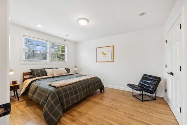 bedroom featuring a closet, recessed lighting, light wood-style flooring, and baseboards