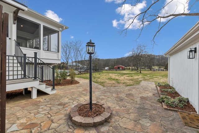 view of patio with a sunroom and stairway