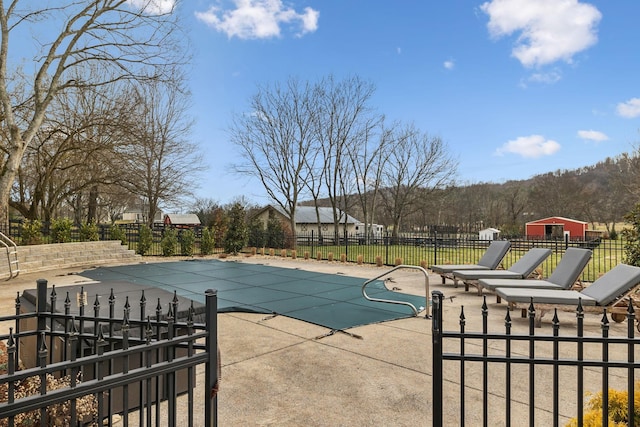 view of swimming pool with a patio area, fence, and a fenced in pool