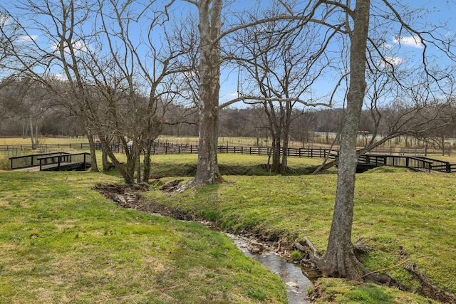 view of yard with a rural view and fence