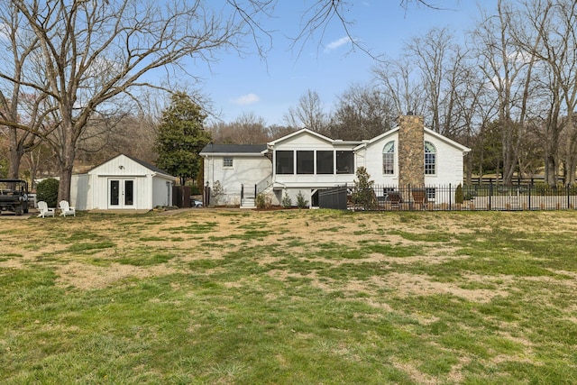 rear view of house with french doors, a chimney, a lawn, fence, and an outdoor structure