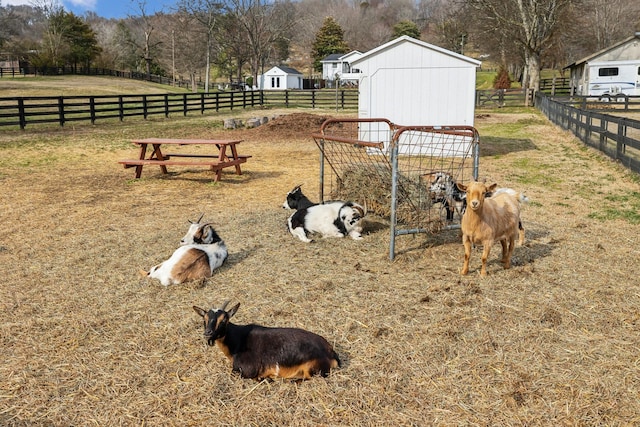 exterior space with a rural view, an outdoor structure, and fence