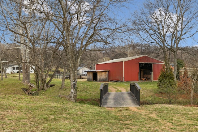 view of yard with fence, an outdoor structure, and an outbuilding