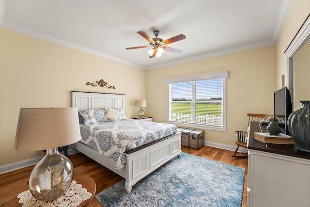 bedroom featuring crown molding, a ceiling fan, light wood-style flooring, and baseboards