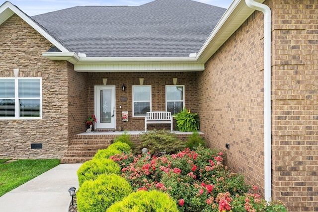 entrance to property with brick siding, crawl space, and a shingled roof