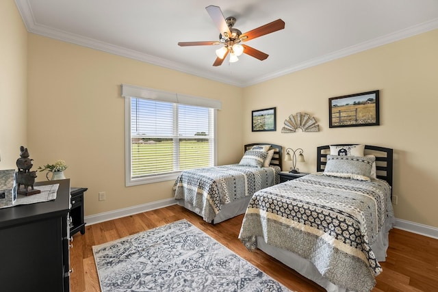 bedroom featuring ornamental molding, a ceiling fan, baseboards, and wood finished floors