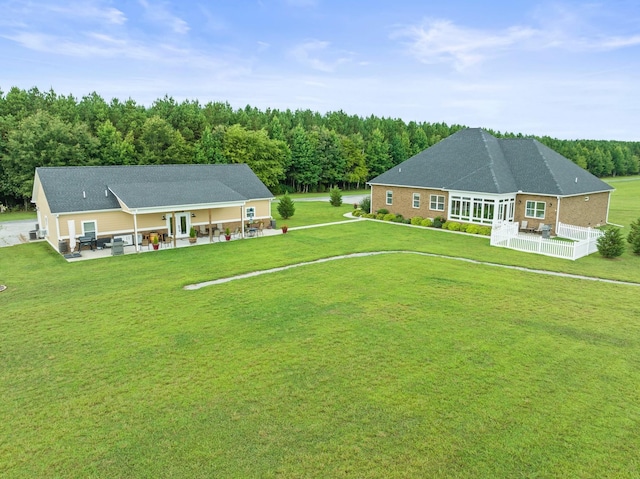 back of house with a patio area and a lawn