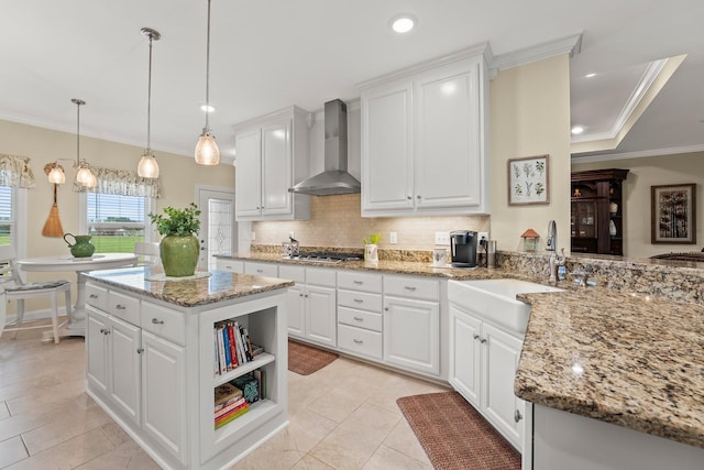 kitchen with stainless steel gas cooktop, tasteful backsplash, wall chimney range hood, and crown molding