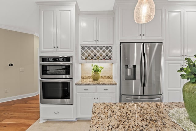 kitchen featuring decorative backsplash, light wood-style flooring, appliances with stainless steel finishes, light stone countertops, and crown molding