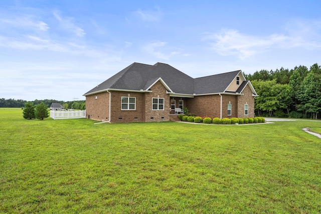 view of front of home featuring brick siding, roof with shingles, crawl space, fence, and a front lawn