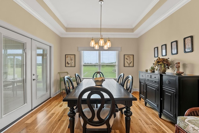 dining area with an inviting chandelier, baseboards, light wood-style floors, and french doors