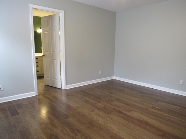 spare room with dark wood finished floors and baseboards