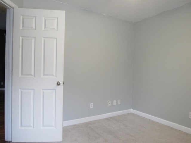 carpeted spare room featuring baseboards