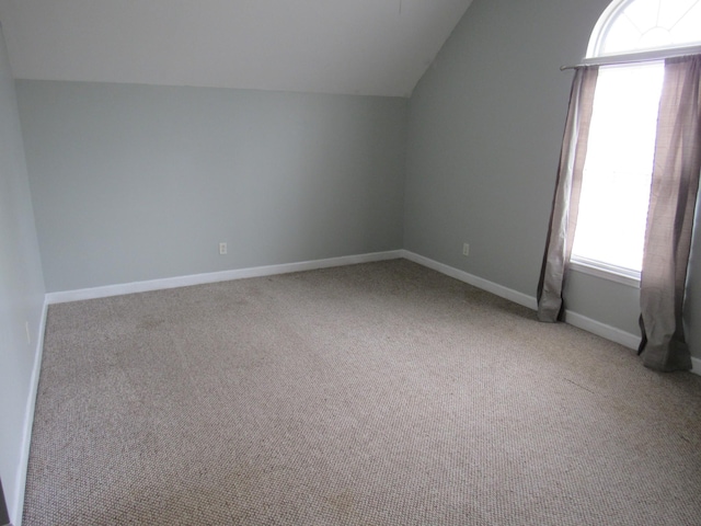 bonus room featuring lofted ceiling, carpet flooring, and baseboards