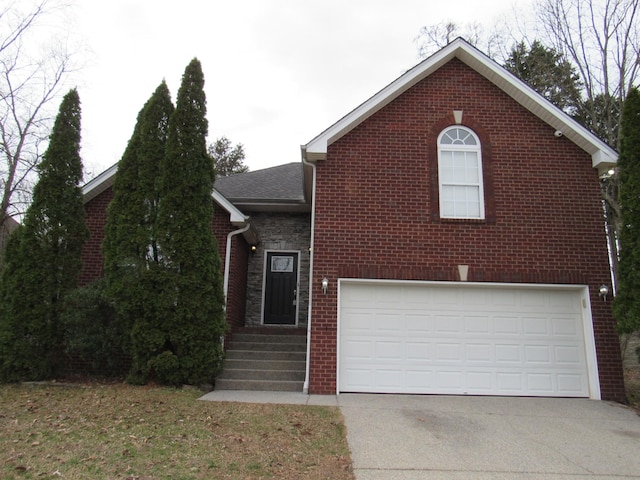 view of front of house with driveway, stone siding, an attached garage, and brick siding