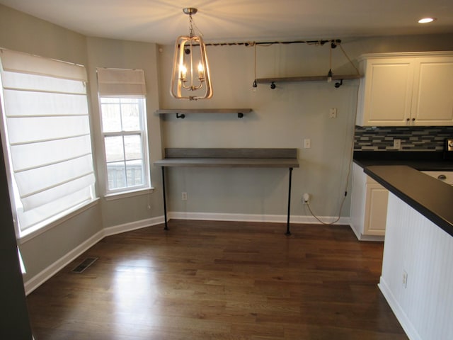 kitchen with tasteful backsplash, dark countertops, visible vents, and dark wood finished floors