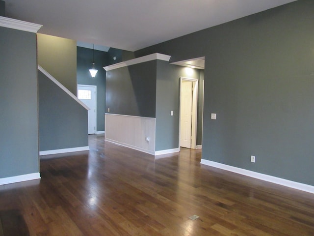 empty room with baseboards and dark wood-type flooring