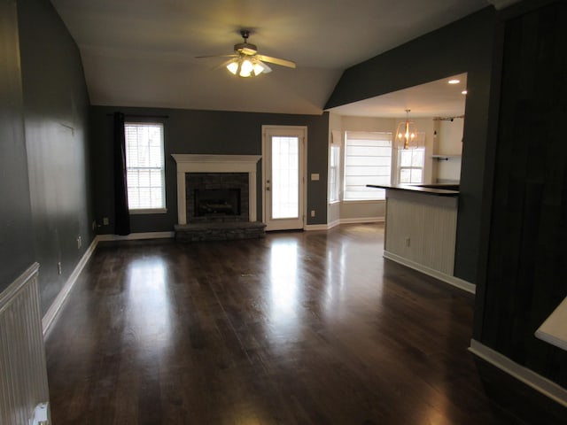 unfurnished living room with a fireplace, lofted ceiling, radiator heating unit, baseboards, and ceiling fan with notable chandelier