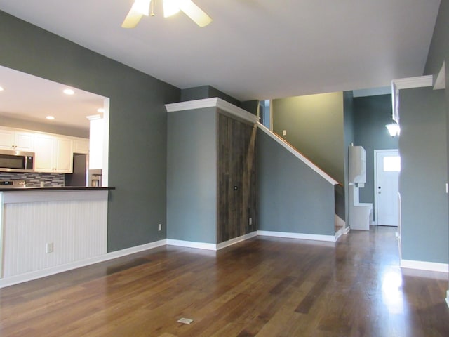 unfurnished living room with dark wood-style floors, recessed lighting, stairway, a ceiling fan, and baseboards