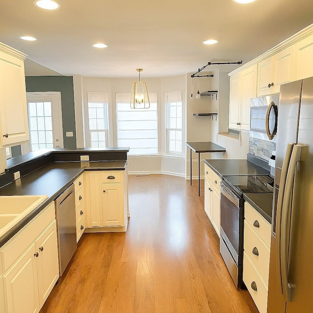 kitchen with dark countertops, a wealth of natural light, and stainless steel appliances