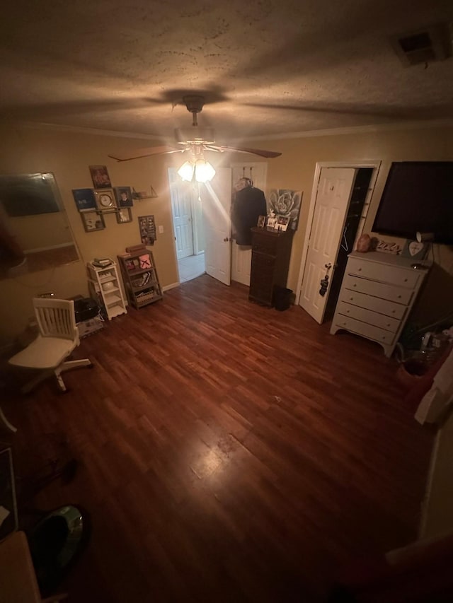 unfurnished bedroom with visible vents, ceiling fan, ornamental molding, wood finished floors, and a textured ceiling