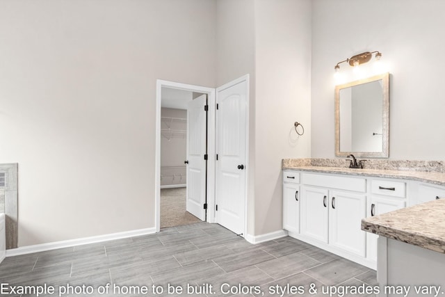 bathroom featuring wood tiled floor, baseboards, and vanity