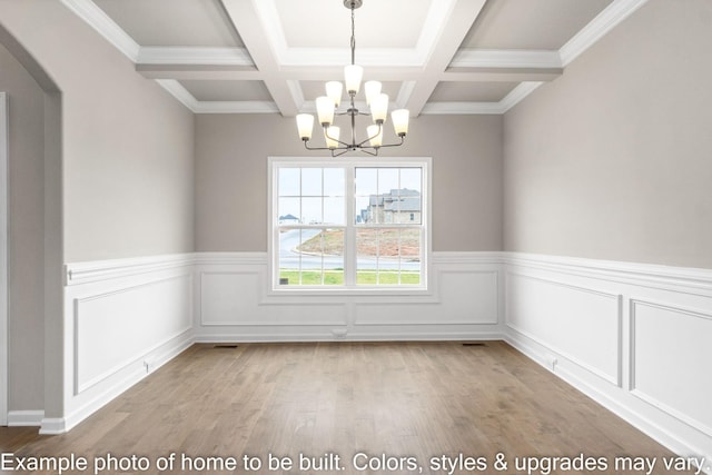 unfurnished dining area with a notable chandelier, a wainscoted wall, coffered ceiling, light wood-style floors, and beamed ceiling