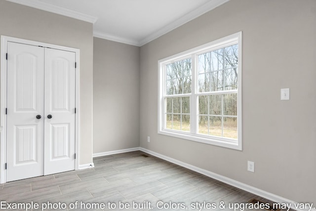 unfurnished bedroom with ornamental molding, wood tiled floor, a closet, and baseboards