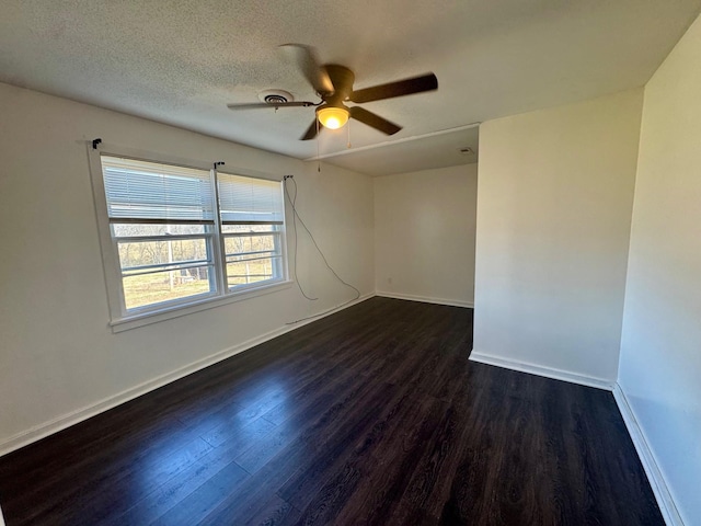 unfurnished room with a textured ceiling, ceiling fan, dark wood-style flooring, and baseboards