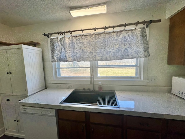 kitchen with a textured ceiling, a textured wall, white dishwasher, an AC wall unit, and light countertops