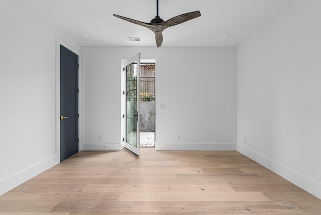 spare room featuring a ceiling fan, baseboards, and wood finished floors