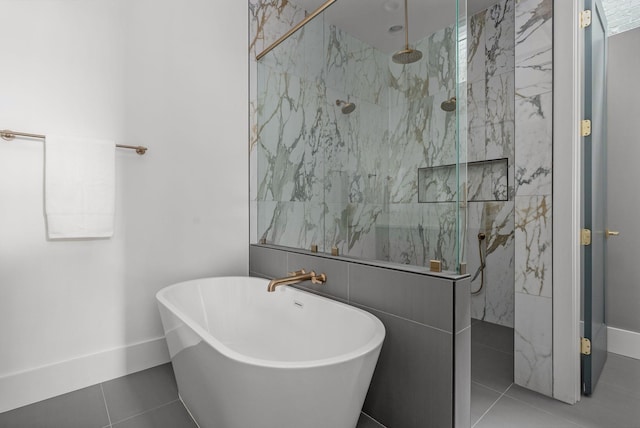 full bathroom with a freestanding bath, tile patterned flooring, a marble finish shower, and baseboards