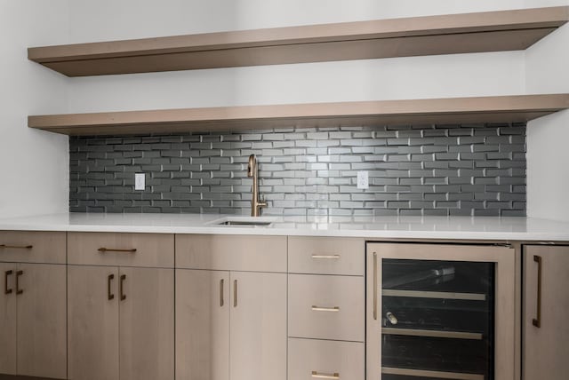 bar with beverage cooler, backsplash, and a sink