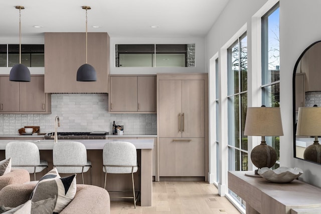 kitchen with light countertops, tasteful backsplash, modern cabinets, and light wood-style floors