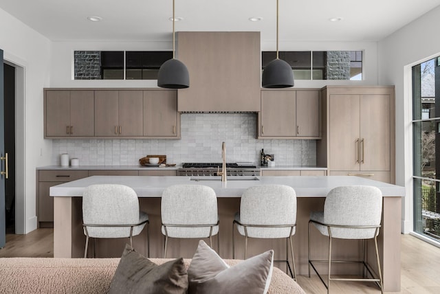 kitchen featuring light countertops, a breakfast bar, and light wood-style floors