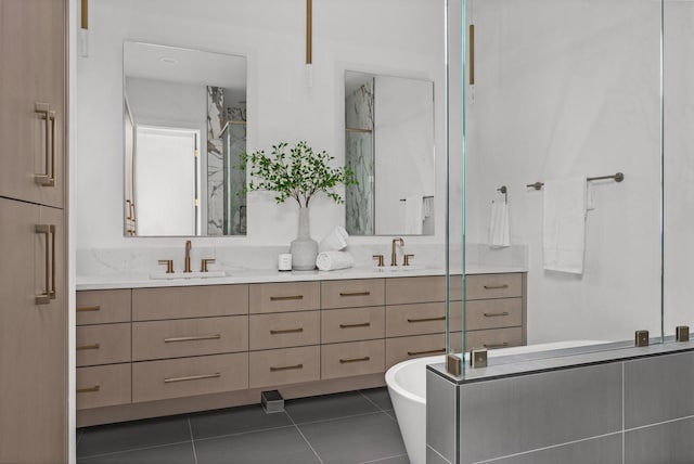 bathroom with double vanity, a stall shower, a sink, and tile patterned floors