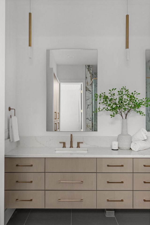 full bathroom featuring a marble finish shower and vanity