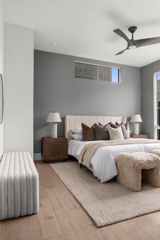 bedroom with a ceiling fan, baseboards, and wood finished floors