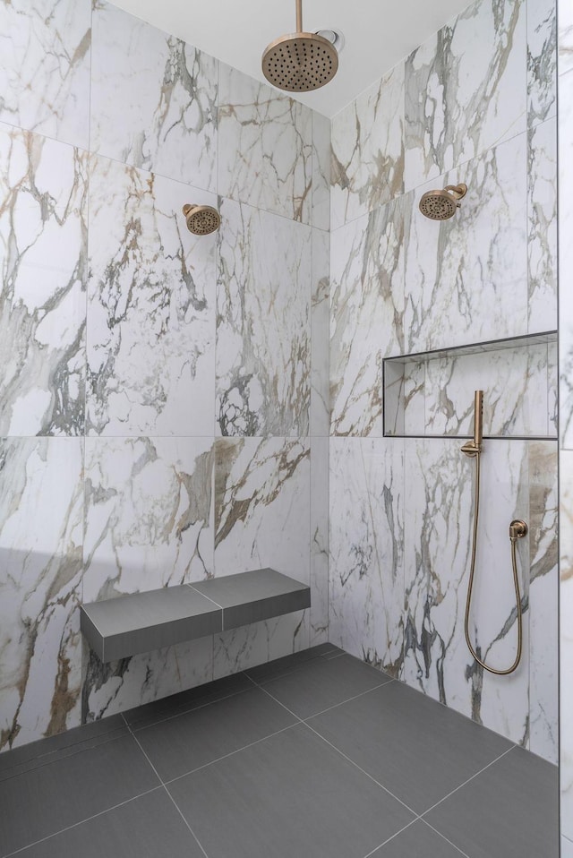 bathroom featuring tile patterned flooring and a marble finish shower