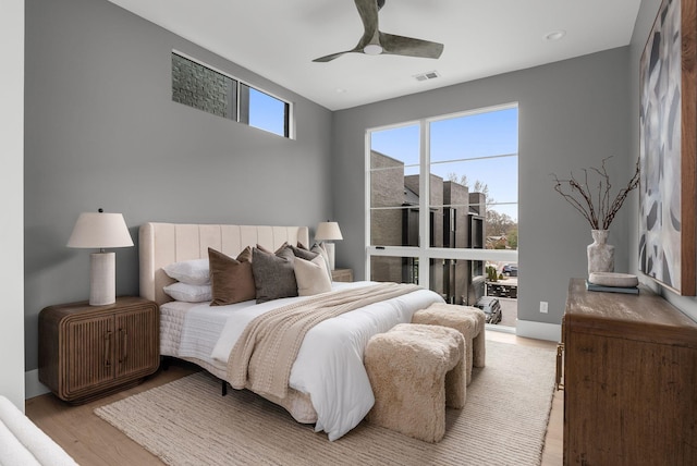 bedroom featuring light wood-style flooring, visible vents, and a ceiling fan