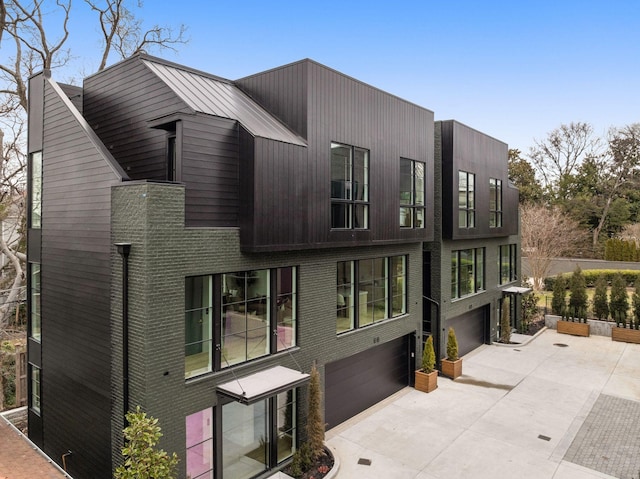 exterior space featuring driveway, a garage, and brick siding