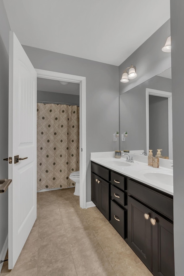 full bath featuring double vanity, a shower with shower curtain, a sink, and toilet