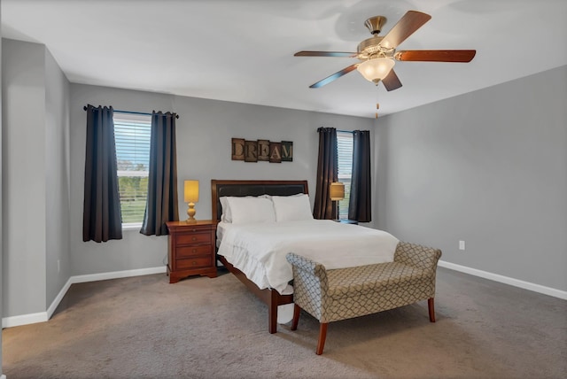 carpeted bedroom with ceiling fan, multiple windows, and baseboards