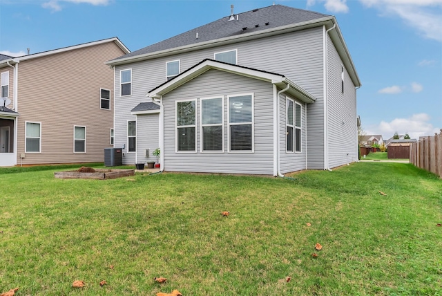 rear view of house with a lawn and fence