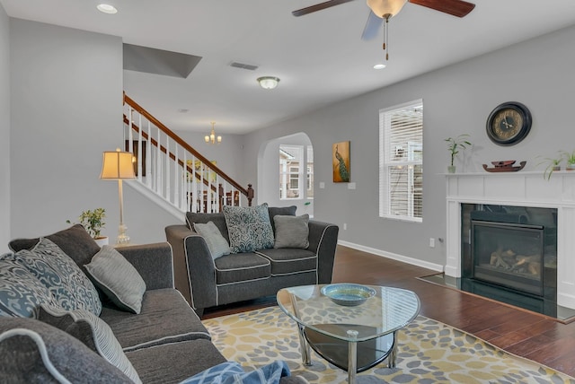 living room with visible vents, a high end fireplace, wood finished floors, baseboards, and stairs