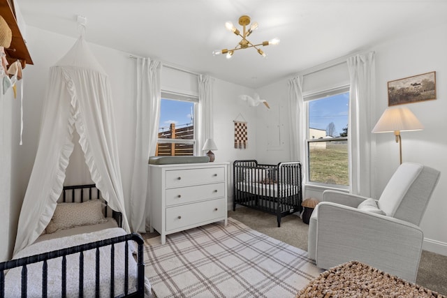 bedroom featuring light carpet, multiple windows, and an inviting chandelier